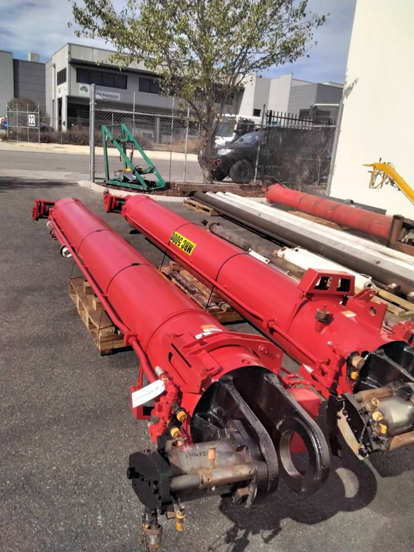 Large red hydraulic boom cylinders